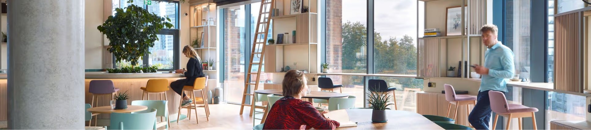 Modern coworking space with people working and natural light.