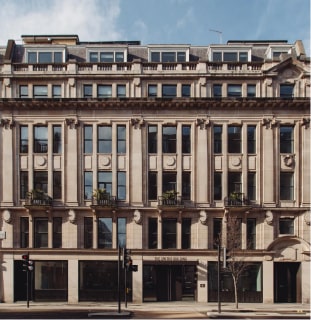 Historic urban building with symmetrical facade and large windows on a sunny day.